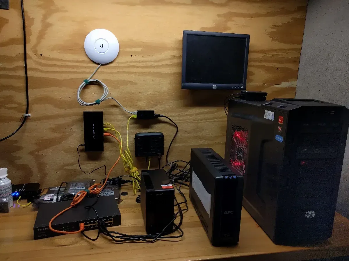 Small computers and network devices connected across the original wooden workbench.
