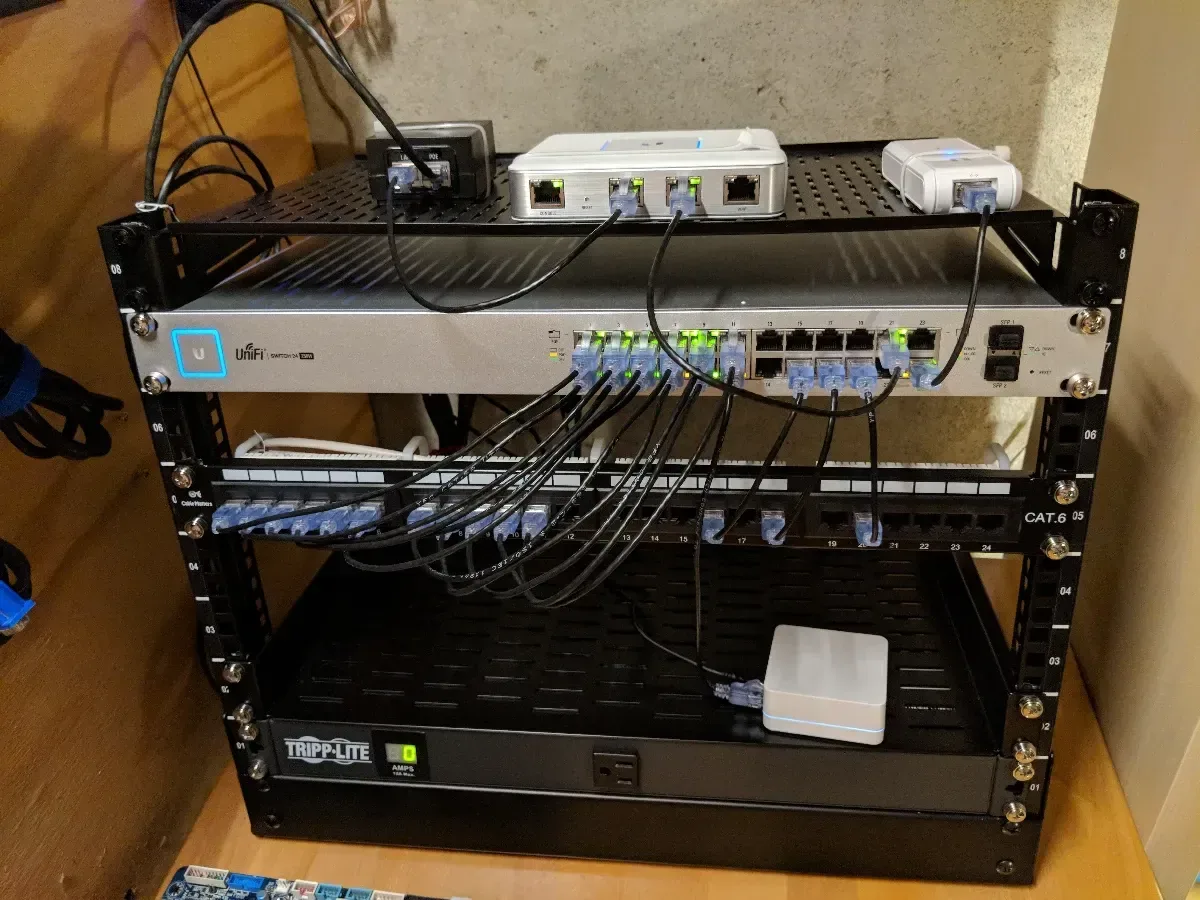 Full network rack with switches, patch panels, organized cabling, and a UPS.