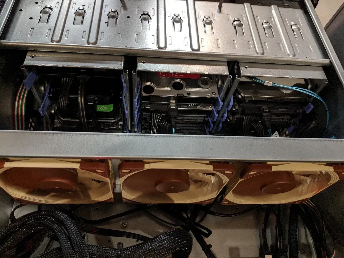 Open rackmount server showing internal drive bays, cooling fans, and cabling.