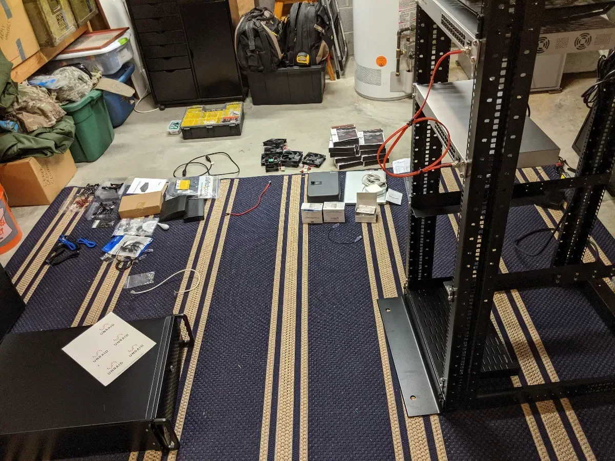 Rack rails, hardware, and small devices laid out on the floor during assembly.