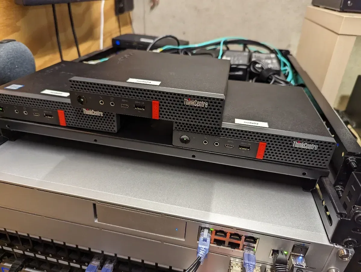 Stack of Lenovo Tiny computers resting on top of a rackmount server.