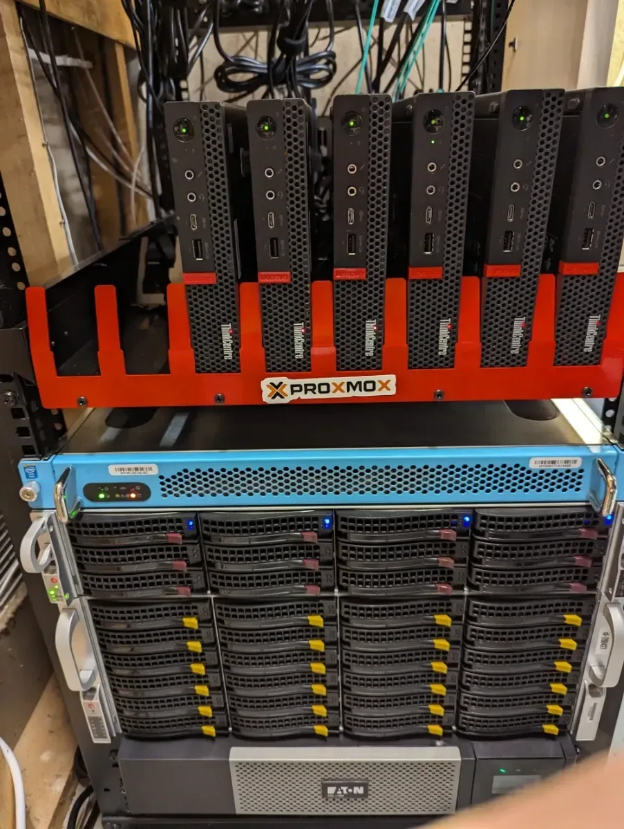 Rack with a red-mounted mini PC cluster installed above two storage arrays.