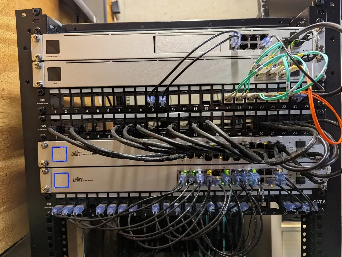 Close-up of patch panels, network switches, and fiber cabling in the rack.