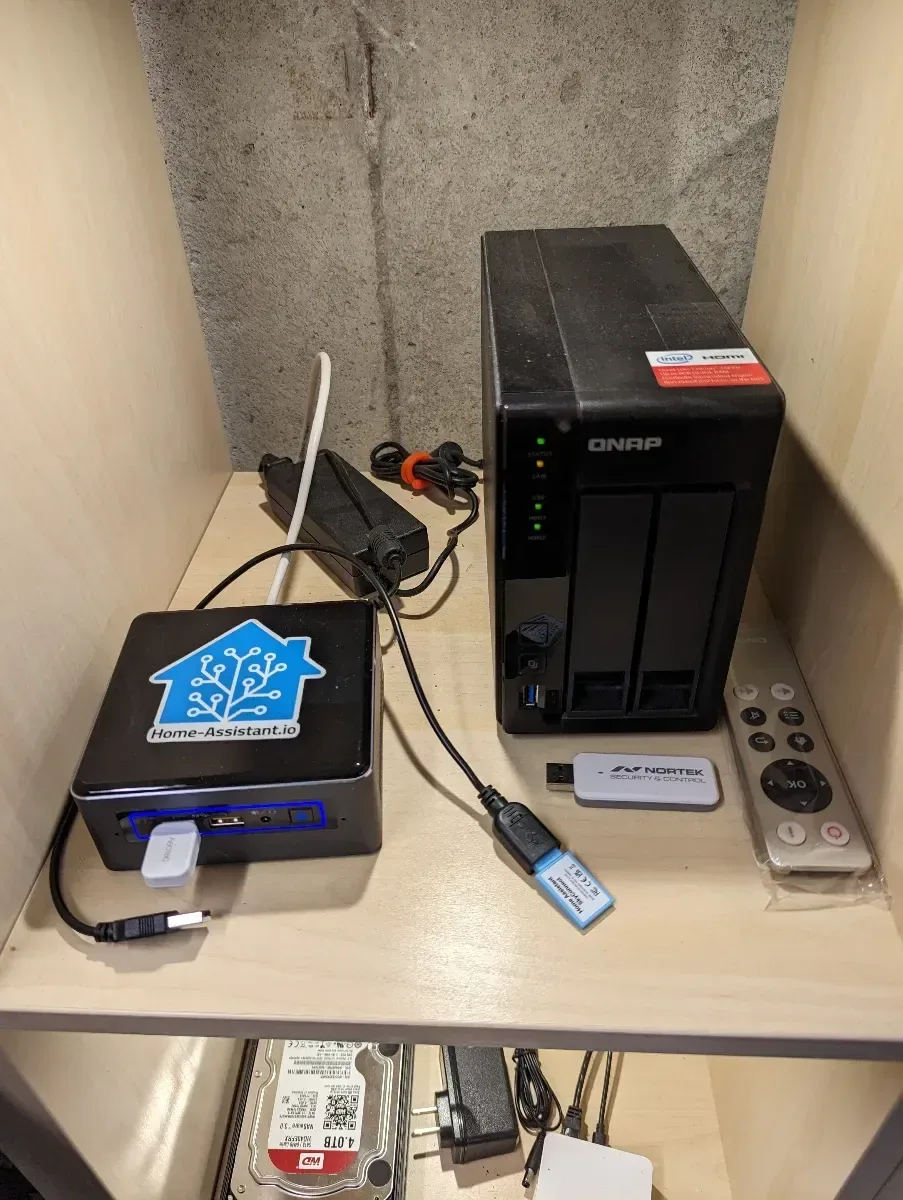Small Home Assistant computer and storage device on a shelf.