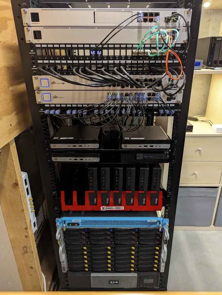 Upgraded rack with patch panels, switches, mini PCs, and storage hardware.