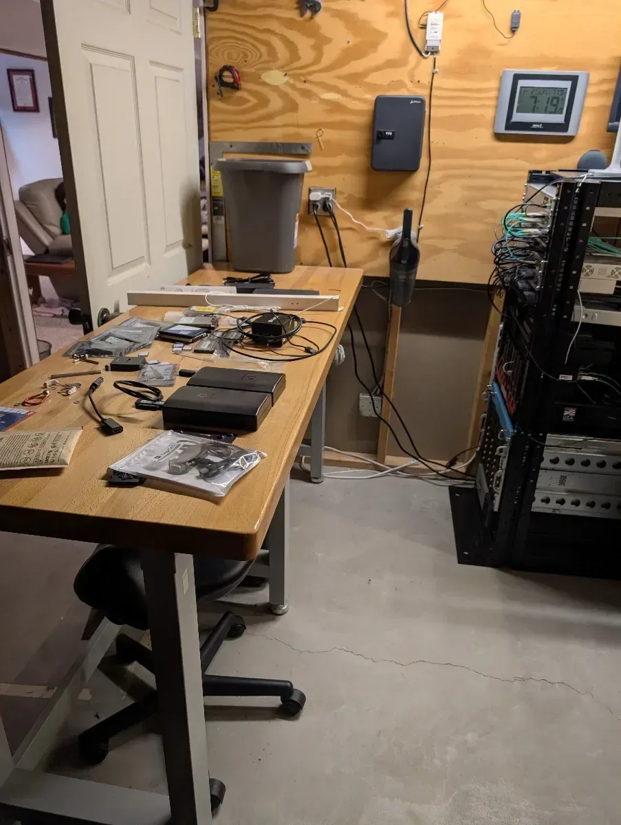 Workbench beside the loaded rack during a homelab upgrade.
