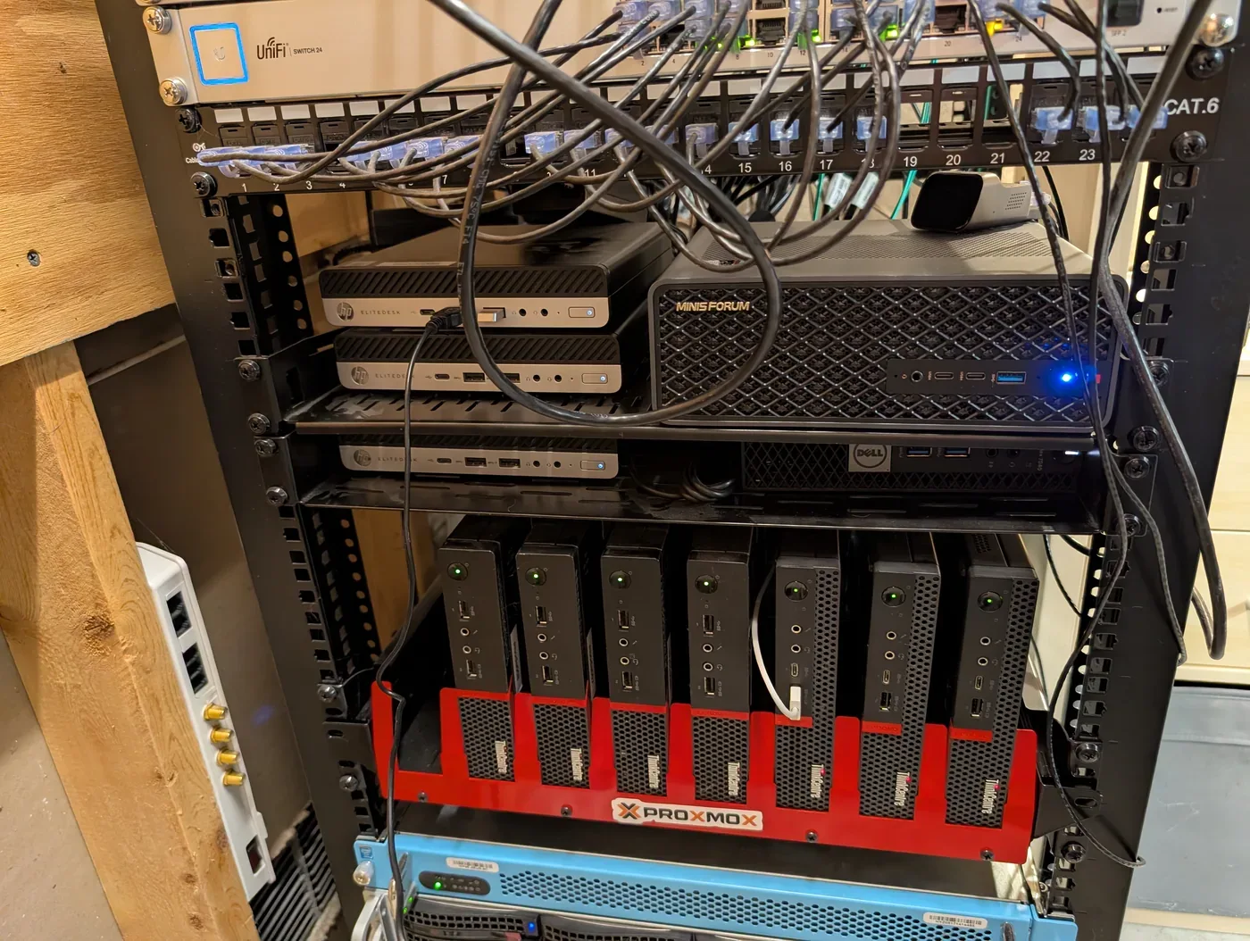 Close-up of the 2026 rack showing a UniFi switch, patch panels, HP EliteDesk nodes, a Minisforum system, and Lenovo Tiny computers.