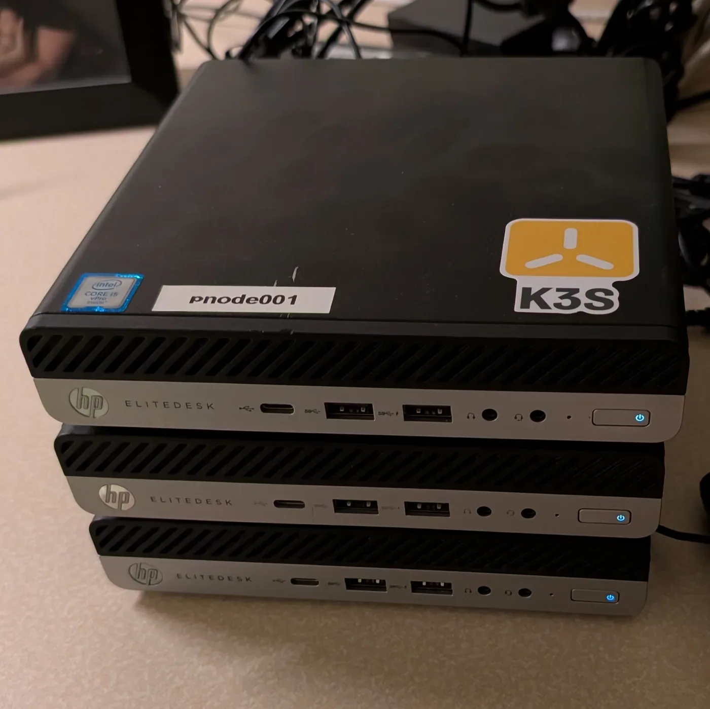 Three stacked HP EliteDesk mini PCs, including pnode001 marked for the K3s cluster.